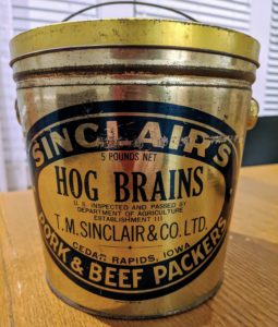 a golden 5-pound bucket that says "HOG BRAINS"